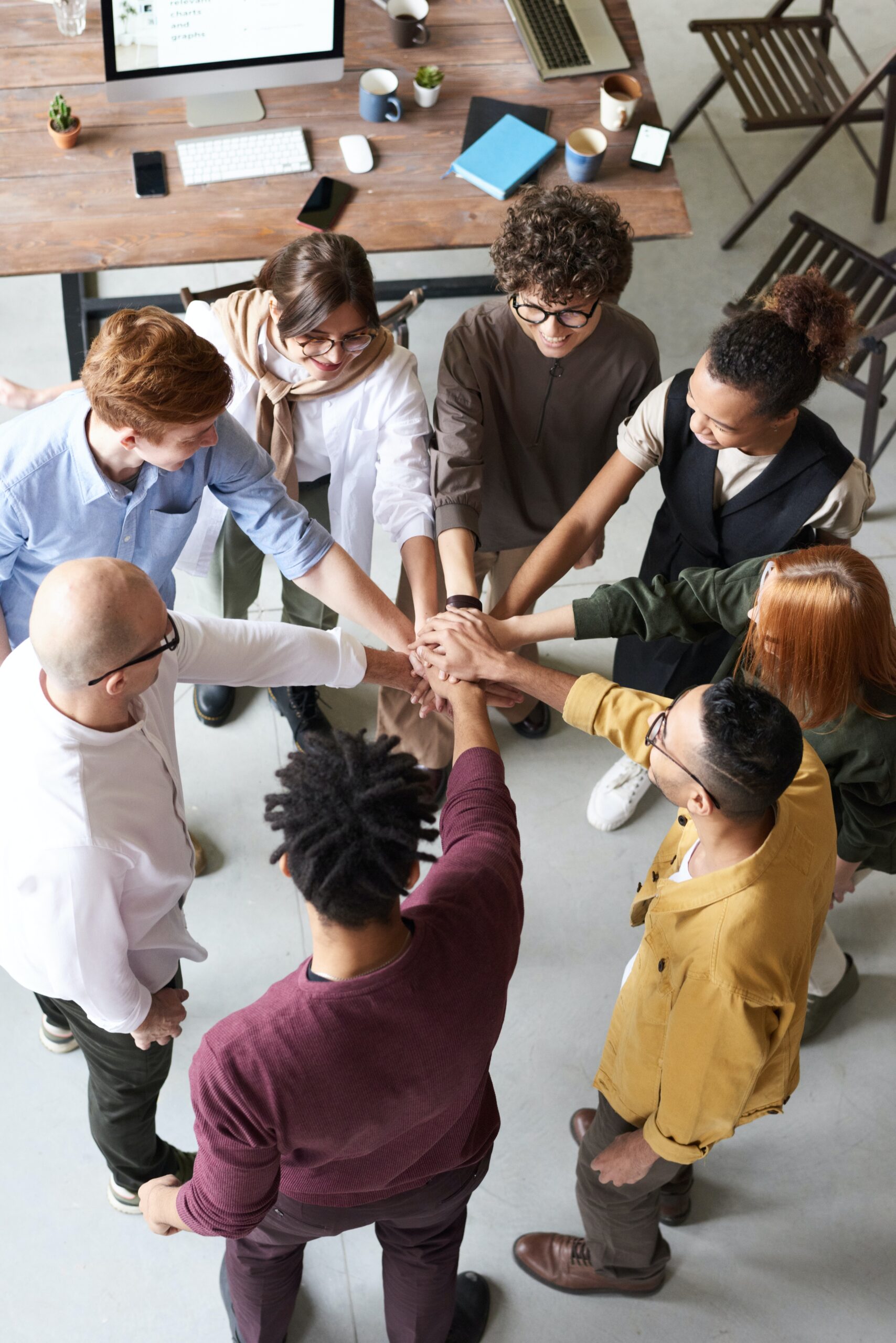 Staff team in a circle holding hands